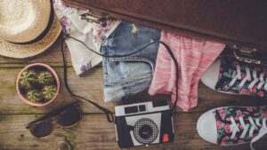 Half packed suitcase with clothing and camera
